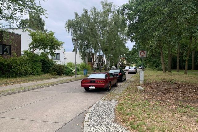 Straße mit parkenden Autos am rechten Straßenrand