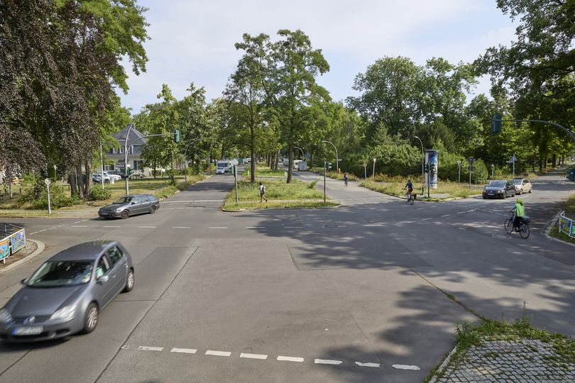 Berliner Stadtkreuzung mit Autos, Fahrrädern und Ampelanlage – fehlende geschützte Radwege und unzureichende Infrastruktur für sicheren Radverkehr