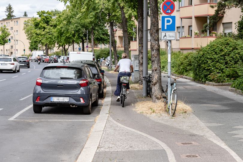 Fahrradfahrerin fährt auf schmalen Hochbordradweg