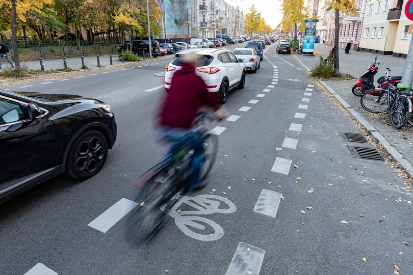 Fahrradschutzstreifen mit Fahrradicon entlang viel befahrener Straße Opernroute Nord