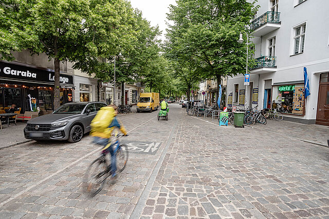 Fahrradfahrer auf einer Straße mit geschliffenem Kopfsteinpflaster