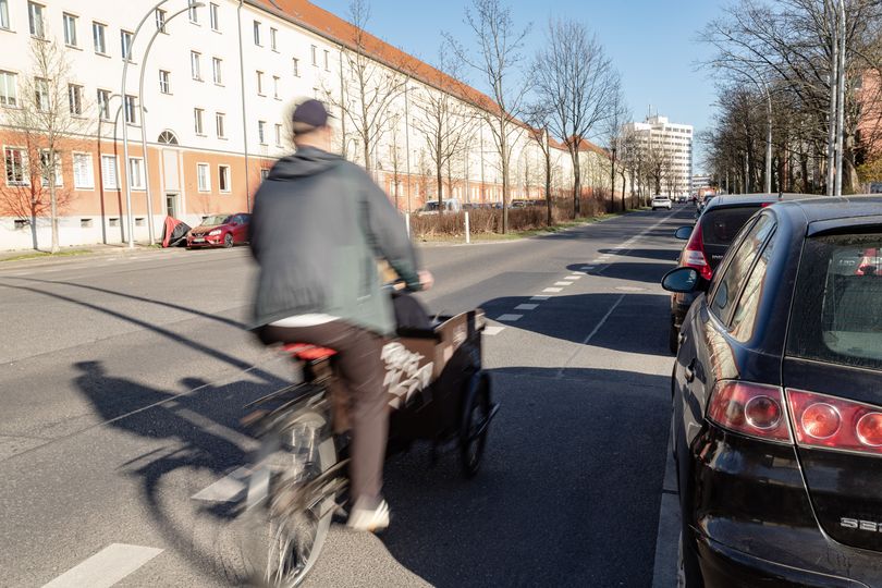 Ein Lastenradfahrer fährt auf einem Radfahrstreifen auf der Straße