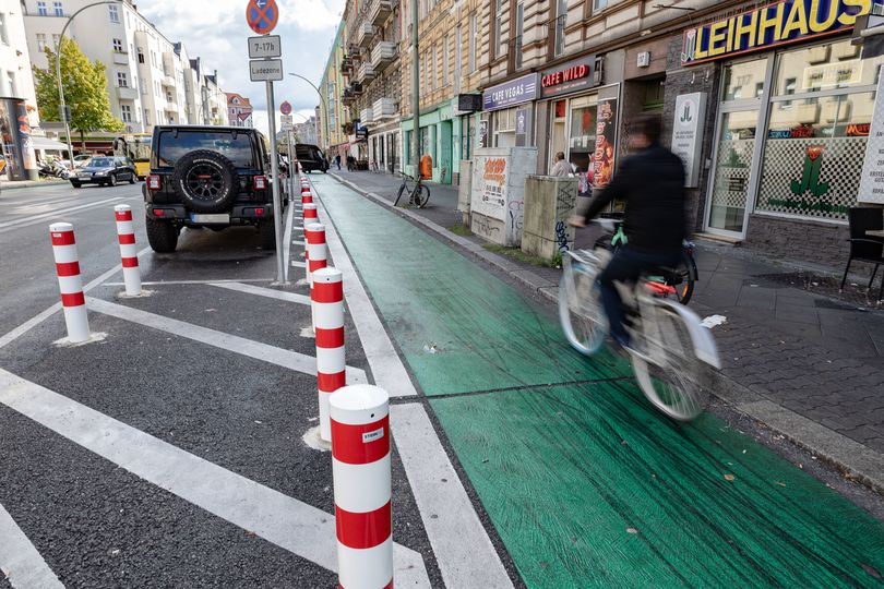 Radfahrer fährt auf Radfahrstreifen, der mit Sicherheitspollern geschützt ist