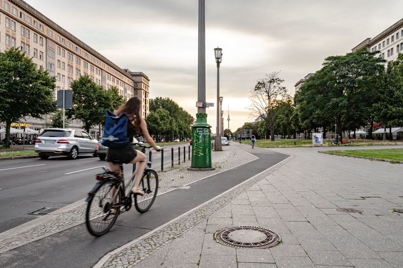 Radfahrende auf Radweg entlang Karl-Marx-Allee