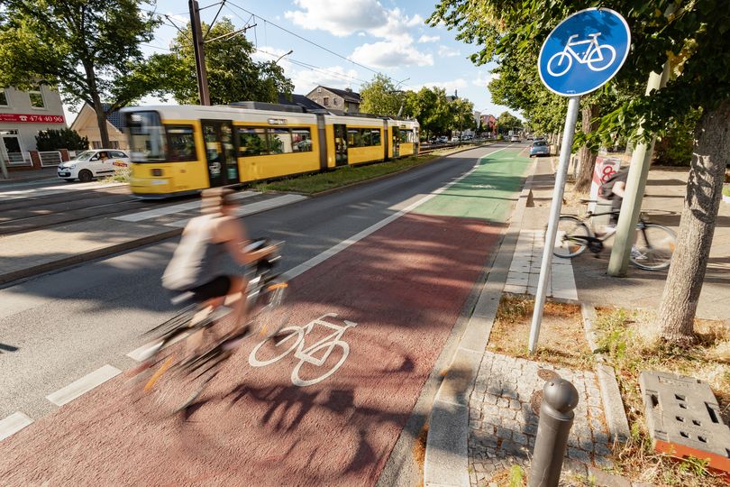 Fahrradfahrer fährt auf einem rot und grün markiertem Radfahrstreifen