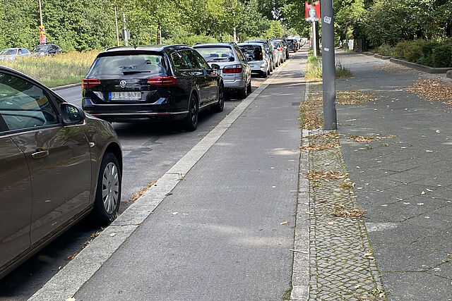 Radweg an der Wuhlheide zwischen Gehweg und parkenden Autos