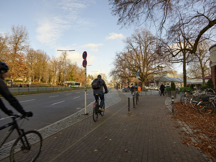 Radfahrende fahren vorbei an S-Bahnhof Wannsee
