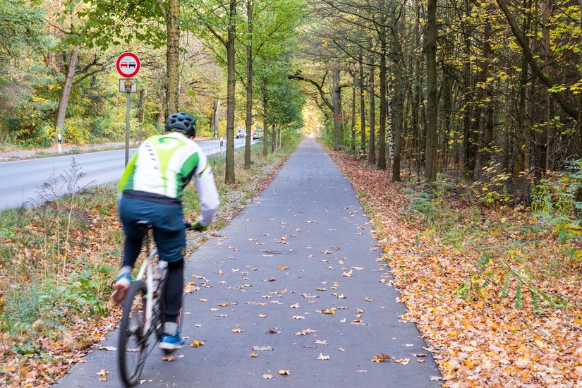 Radfahrer auf asphaltiertem Radweg entlang Fürstenwalder Allee