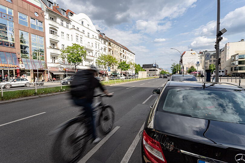 Blick auf die Müllerstraße am Leopoldplatz ohne Infrastruktur für Radfahrende, parkende Autos am rechten Fahrbahnrand