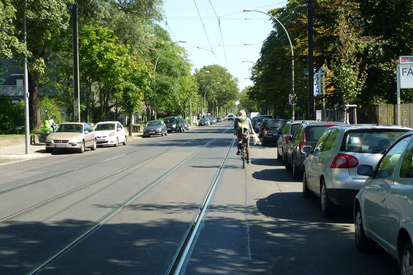 Verkehrssituation Herzbergstraße mit Autoverkehr Tram Radfahrenden und parkenden Autos