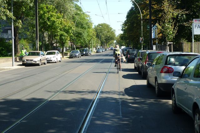 Verkehrssituation Herzbergstraße mit Autoverkehr Tram Radfahrenden und parkenden Autos