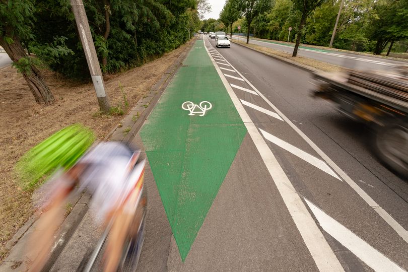 Fahrradfahrer auf grünmarkiertem Radfahrstreifen in Pfeilform Alt-Biesdorf, Märkische Allee