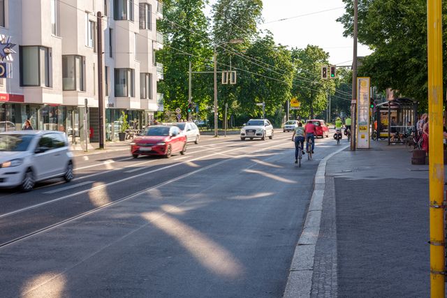 Radfahrende auf Hermann-Hesse-Straße neben Autos
