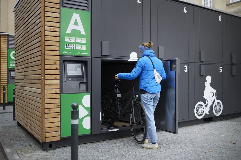 Frau stellt Fahrrad ein in Einzelbox am ParkYourBike Standort in Schöneberg