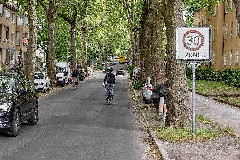 Radfahrende auf asphaltierter Autostraße entlang des Tietzenweg mit Zone 30.