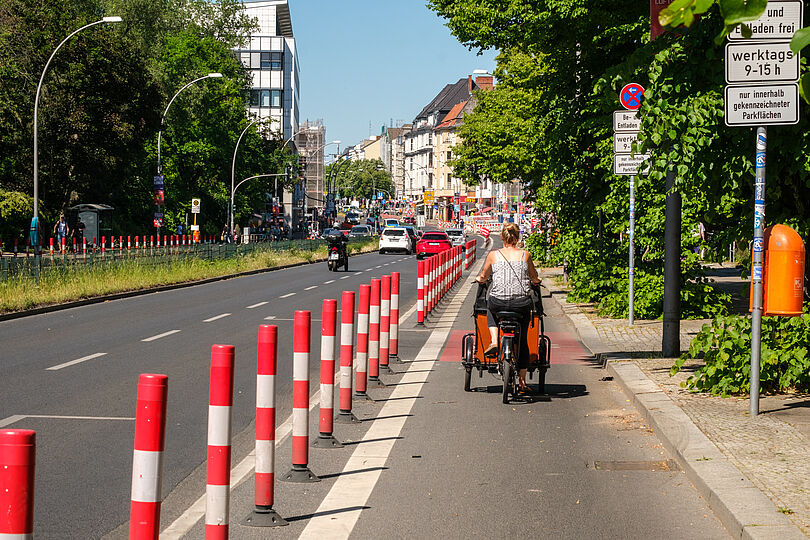 Radfahrerin mit Lastenrad fährt entlang geschütztem Radfahrstreifen auf Tempelhofer Damm