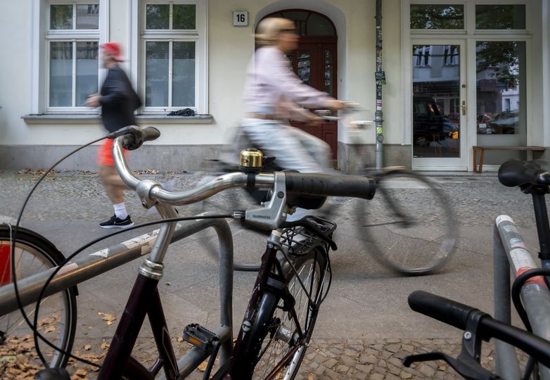 Fahrradfahrerin und Jogger auf einem Bürgersteig