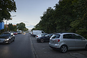 Autostraße mit Querparkplätzen an der rechten Straßenrand.