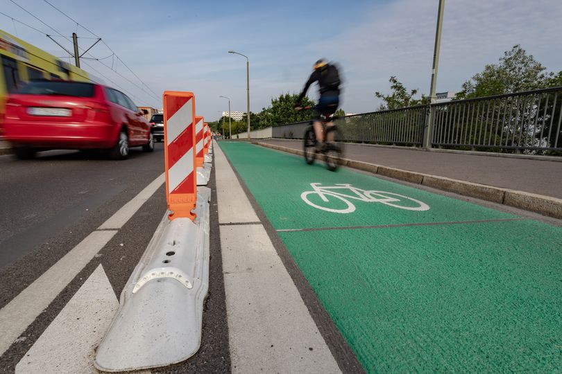 Radfahrer fährt auf geschütztem und grün markierten Radfahrstreifen Allee der Kosmonauten