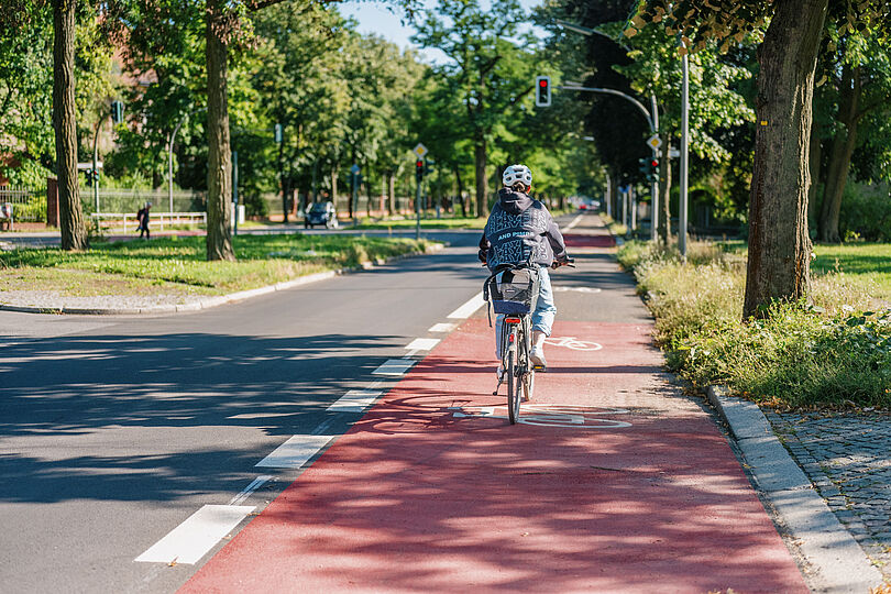 Fahrradfahrerin fährt auf einem Radfahrstreifen, der teilweise rot markiert ist