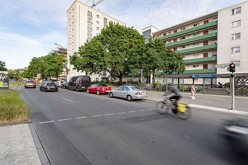 Radfahrende auf einem zweispurigen Autostraße ohne Fahrradweg.