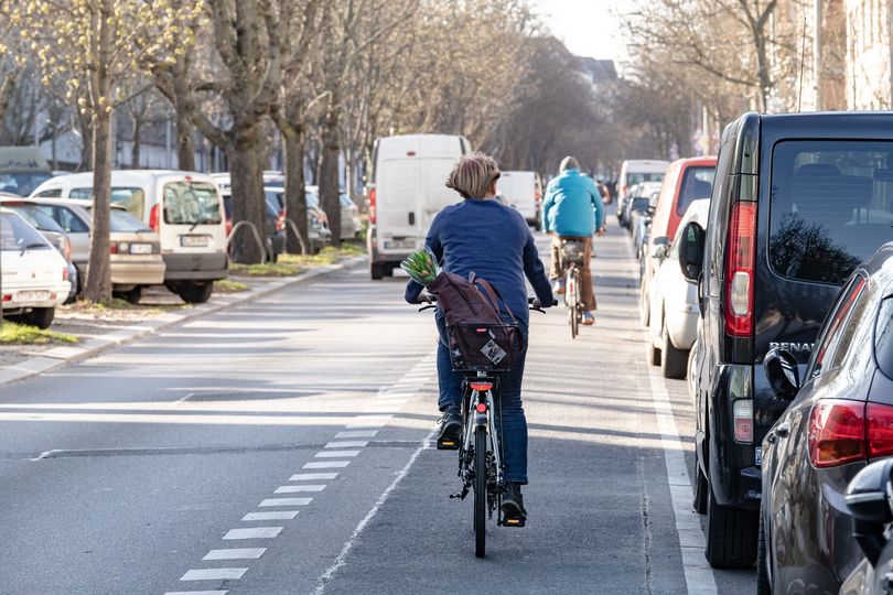 Eine Fahrradfahrerin ist von hinten zu sehen wie sie auf einem Radfahrstreifen fährt in Berlin Prenzlauer Berg