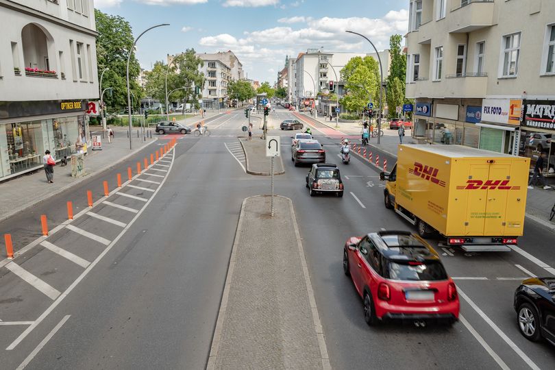 Stadtstraße mit Autoverkehr, markierten Lieferzonen und geschützten Radfahrstreifen