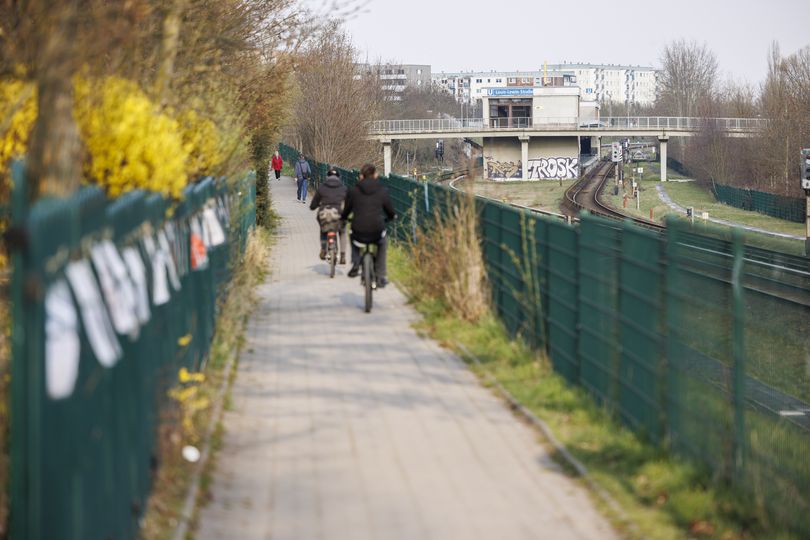 Fahrradfahrer fahren entlang von Bahnschienen in Berlin