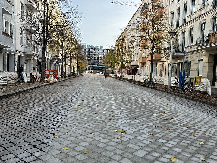 Gefräste Straße mit Kopfsteinpflaster mit einem Radfahrenden.