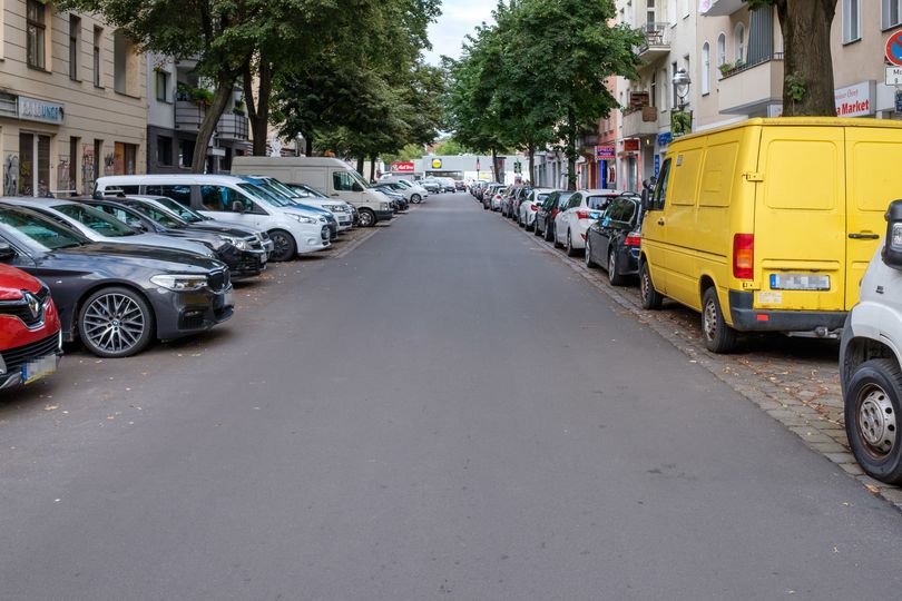 Asphaltierte Fahrradstraße mit parkenden Autos links und rechts der Straße auf Kameruner Straße