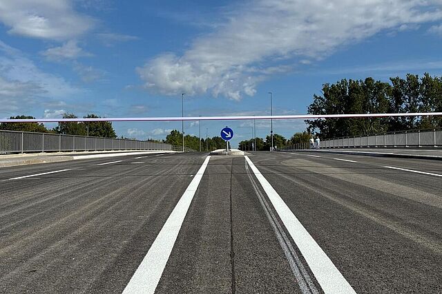 Blick auf den Querschnitt einer neuen Brücke mit Fahrstreifen für Auto- und Radverkehr, Mittelinsel zum Queren