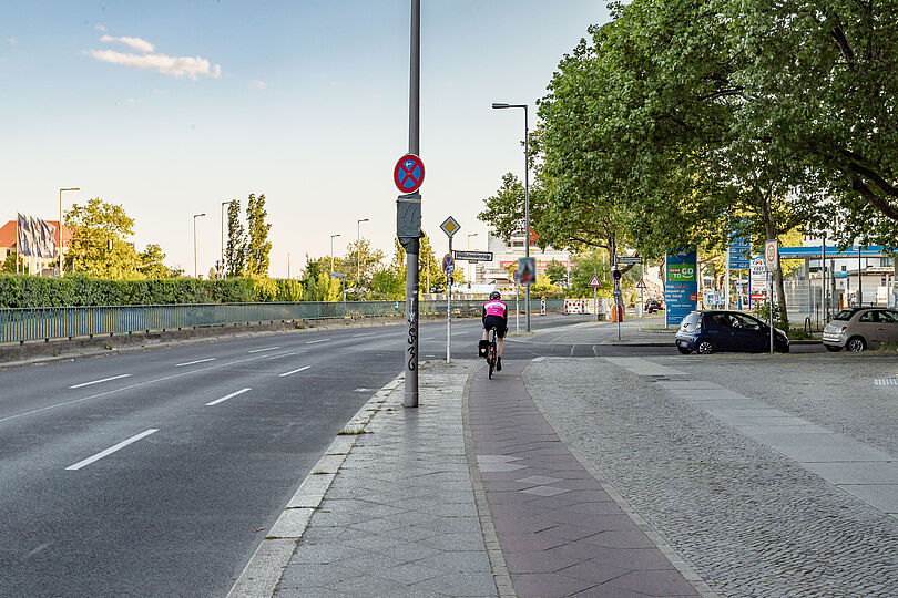 Radfahrende auf einem schmalen Hochboardradweg.