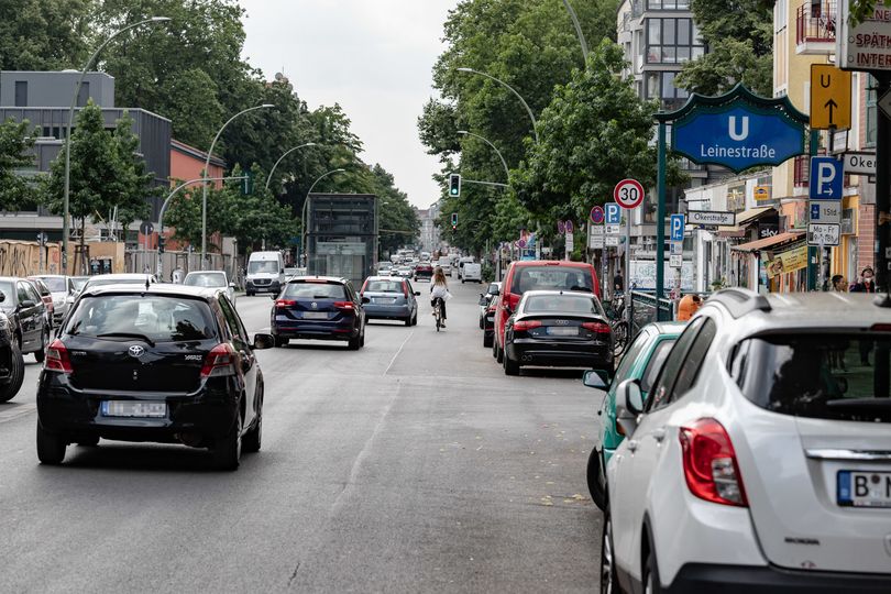 Radlerin auf viel befahrener Hermannstraße rechts parkende Autos Höhe U Leinestraße