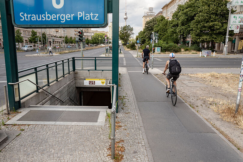 Radfahrende auf einem Hochboardradweg am U-Bahnhof Strausberger Platz