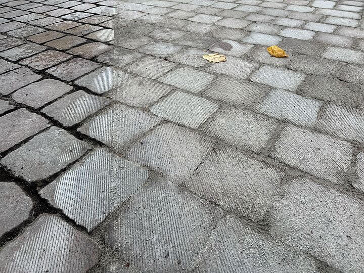 Gefräste und ungefräste Kopfsteinpflaster nebeneinander für ein Vorher-Nachher-Effekt.