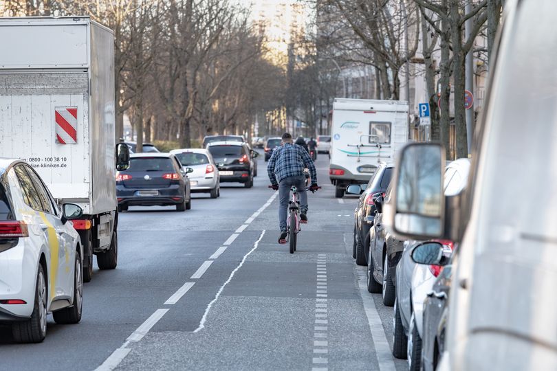 Ein Fahrradfahrer ist von hinten zu sehen wie er auf einem Radfahrstreifen fährt.