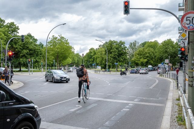 ein Radfahrer wartet vor einer Kreuzung an einer Ampel
