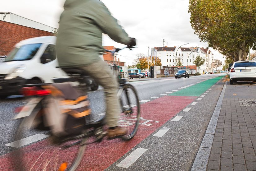 Radfahrer auf Lahnstraße mit grün und rot markiertem Radfahrstreifen