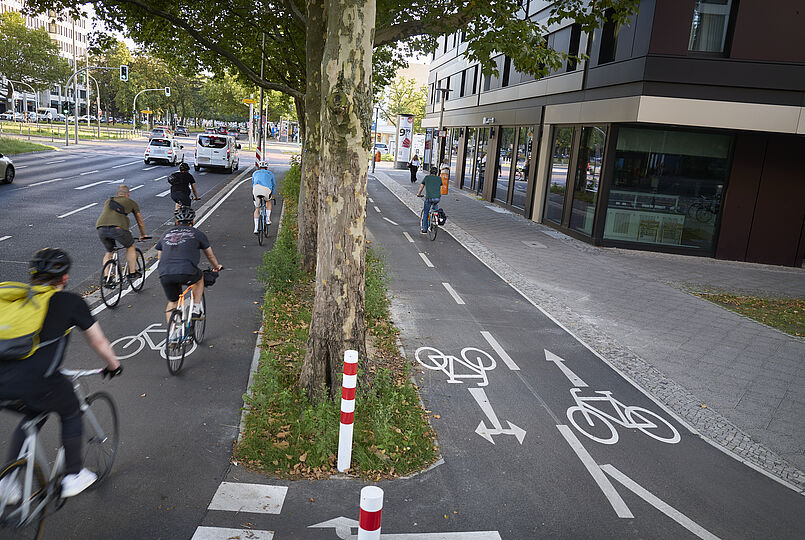 Zweirichtungsradweg und Hochboardradweg mit Piktogrammen und vielen Radfahrenden.