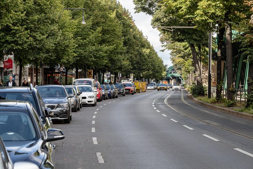 Schönhauser Allee in altem Zustand mit parkenden Autos auf der linken Bildseite.