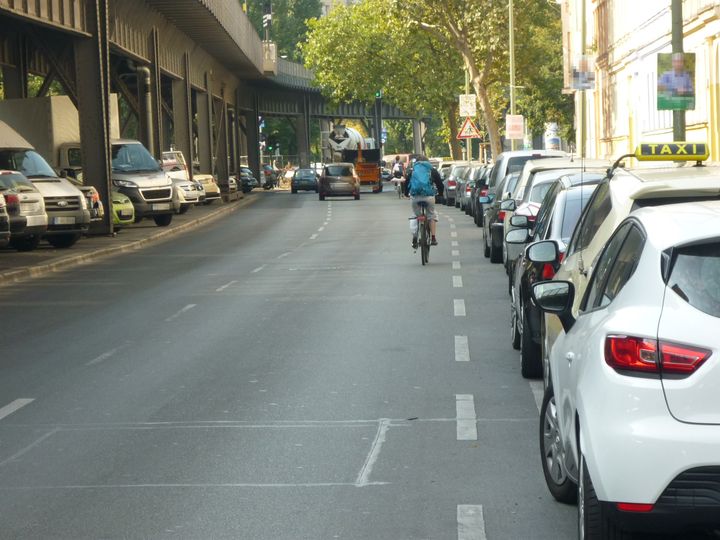 Radfahrer fährt mit auf Straße neben parkenden Autos Gitschiner Straße