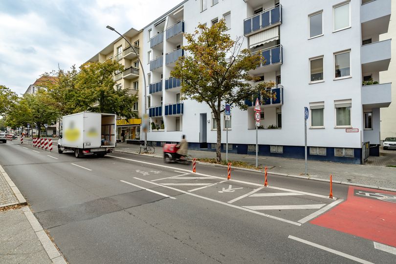 Blick auf eine markierte Ladezone mit Lieferfahrzeug zwischen Fahrbahn und Radfahrstreifen, dahinter markierter Bereich einer Querungsstelle für Fußgänger