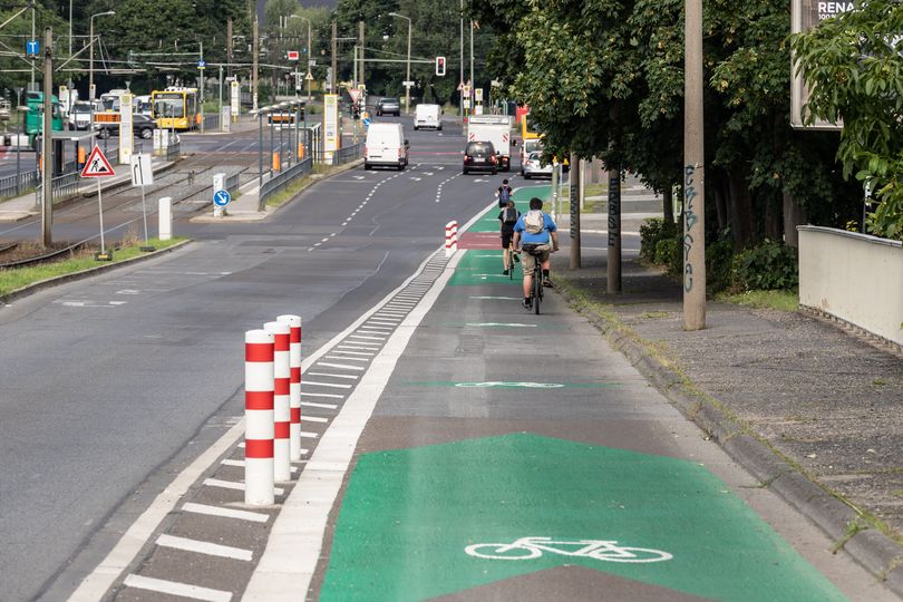 Farblich markierter Radfahrstreifen Allee der Kosmonauten mit teilweise Protektionselementen