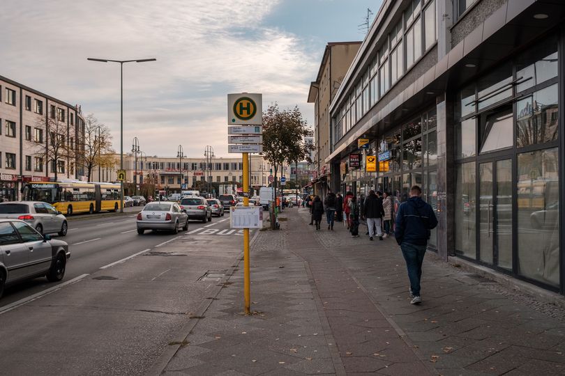 vielspurige Straße mit Bushaltestelle und schmalem Hochbordradweg auf dem Gehweg