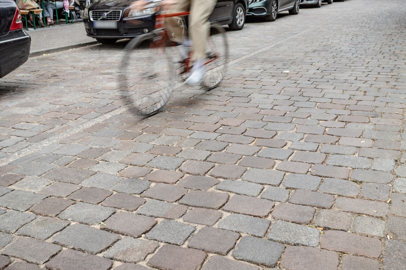 Nahaufnahme eines Fahrrads auf der Fahrbahn mit geschliffenem Kopfsteinpflaster