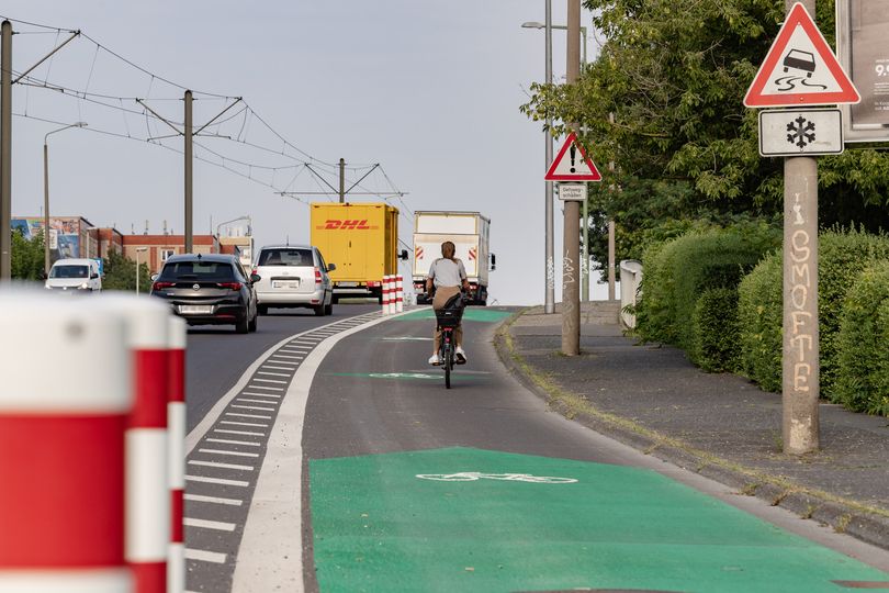 Radfahrstreifen Allee der Kosmonauten mit Protektionselementen und Markierung durch grüne Blockpfeile